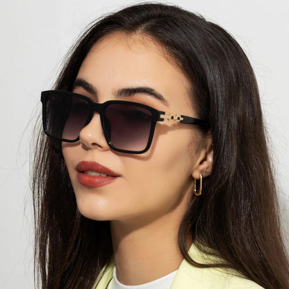 Lorya — Übergroße quadratische Sonnenbrille mit goldenen Kettenglied-Bügeln