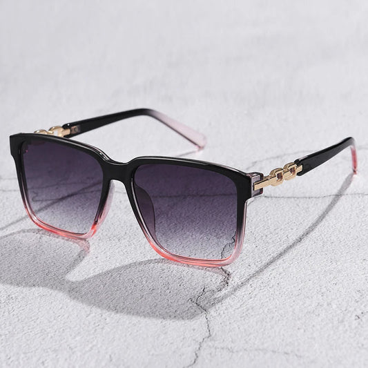 Lorya — Übergroße quadratische Sonnenbrille mit goldenen Kettenglied-Bügeln
