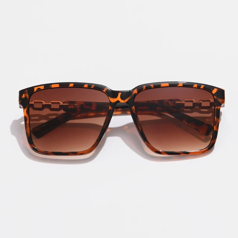 Lorya — Übergroße quadratische Sonnenbrille mit goldenen Kettenglied-Bügeln