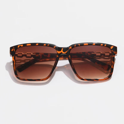 Lorya — Übergroße quadratische Sonnenbrille mit goldenen Kettenglied-Bügeln