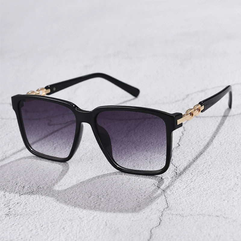 Lorya — Übergroße quadratische Sonnenbrille mit goldenen Kettenglied-Bügeln
