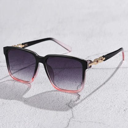 Lorya — Übergroße quadratische Sonnenbrille mit goldenen Kettenglied-Bügeln