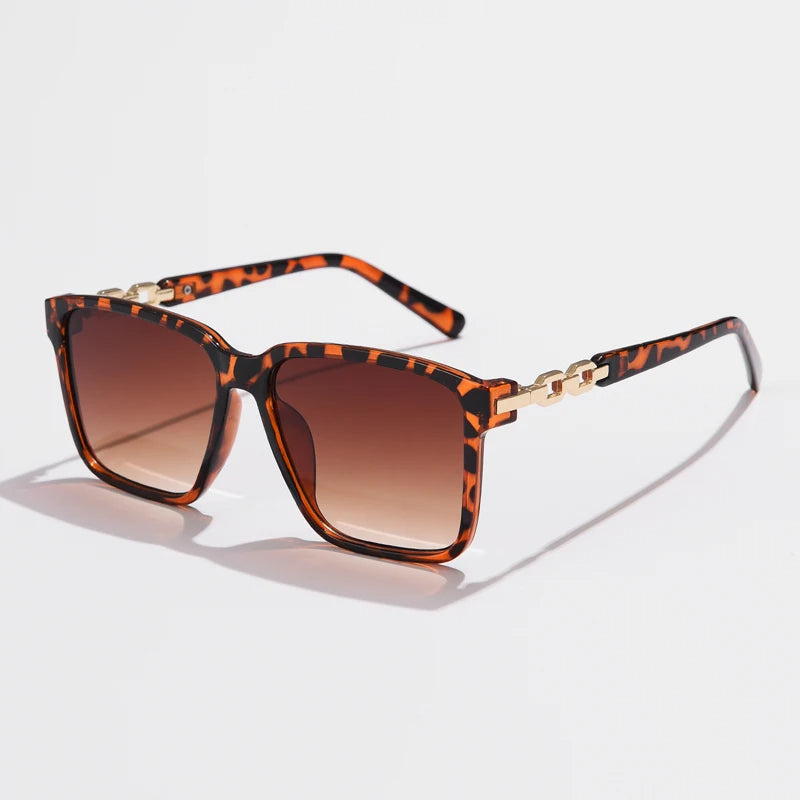 Lorya — Übergroße quadratische Sonnenbrille mit goldenen Kettenglied-Bügeln
