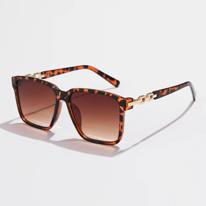 Lorya — Übergroße quadratische Sonnenbrille mit goldenen Kettenglied-Bügeln